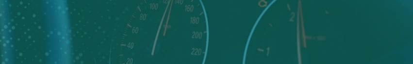 Close-up view of a speedometer and tachometer with a teal background.